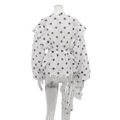 White outfit with black polka dots on a mannequin against a white background