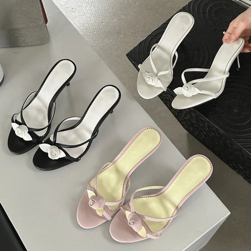 Assortment of flower embellished thin heel mules in various colors