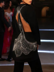 Black blazer with intricate silver beadwork on a red carpet