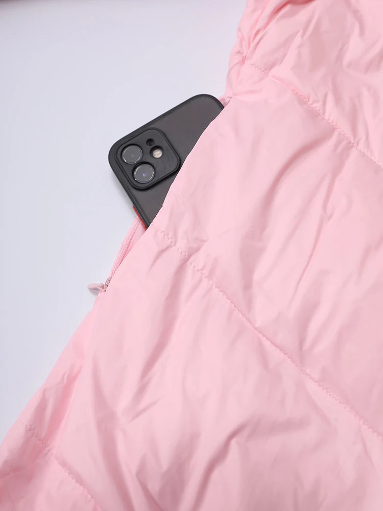 Pink quilted jacket with a black phone on a light gray background
