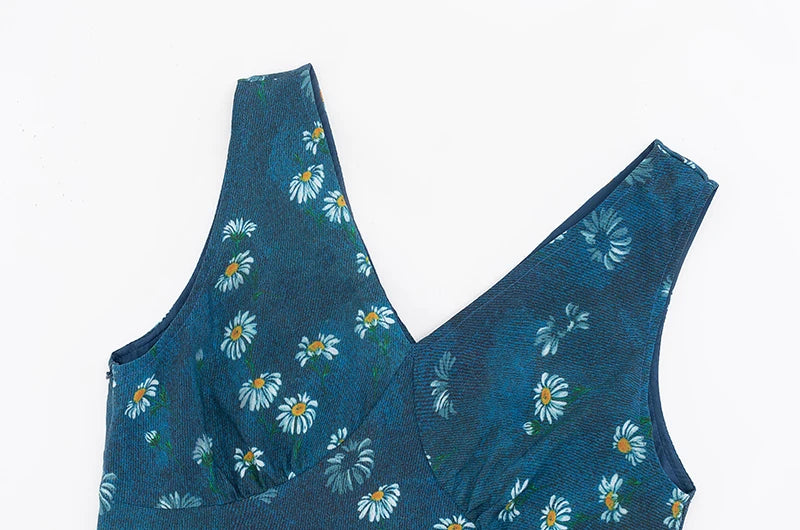 Close-up view of the fabric and V-neckline of a sleeveless mini dress with a blue daisy print.