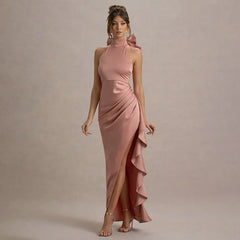 Woman wearing a pink evening gown with a high slit on a beige background