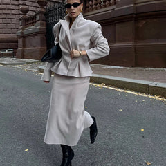 Woman in a gray outfit walking on a street.
