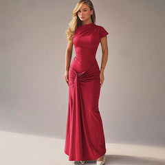  Golden Atelier maxi dress with short sleeves and a tie-up detail at the waist. The dress hugs the curves and is modeled on a woman in a summery setting. Red