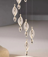 Modern pendant light fixture with hanging glass shades in a minimalistic room.