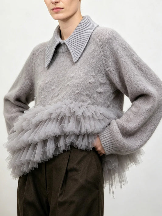 Gray knit sweater with a structured collar and a layered gray tulle ruffle detail at the waist, shown from the side.