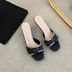 Light blue denim kitten heels with studded metal buckle detail.