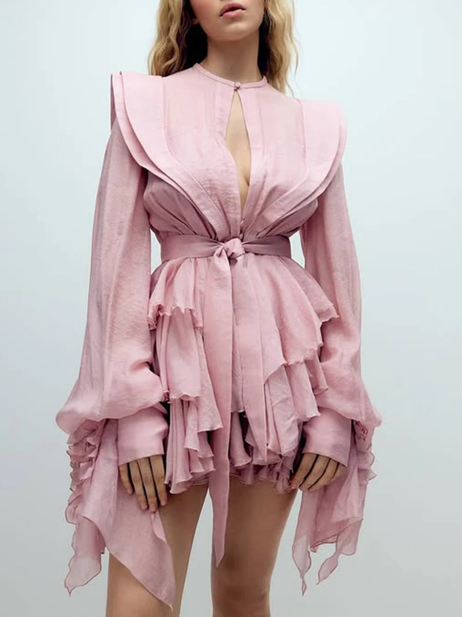 Pink ruffled dress worn by a model on a light gray background