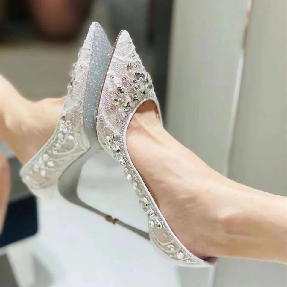 Silver high-heeled shoes with intricate designs on a blurred background