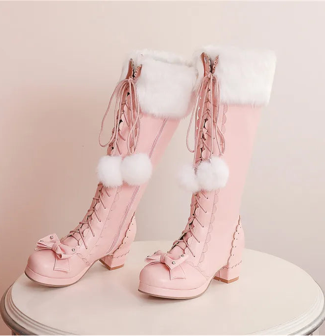 Pink lace-up boots with white fur and pom-poms on a light background