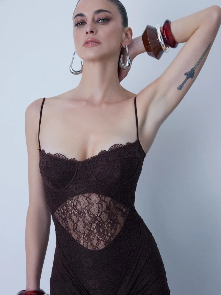 Woman wearing a black lace lingerie set against a plain background