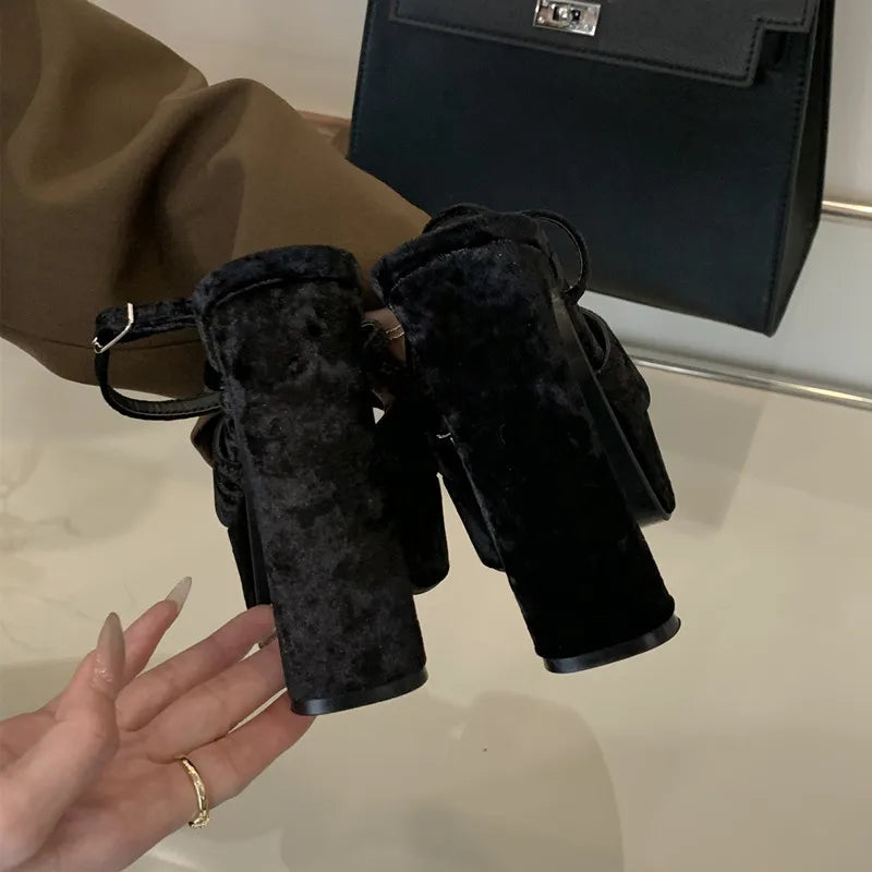 Black binoculars held by a hand with a blurred background