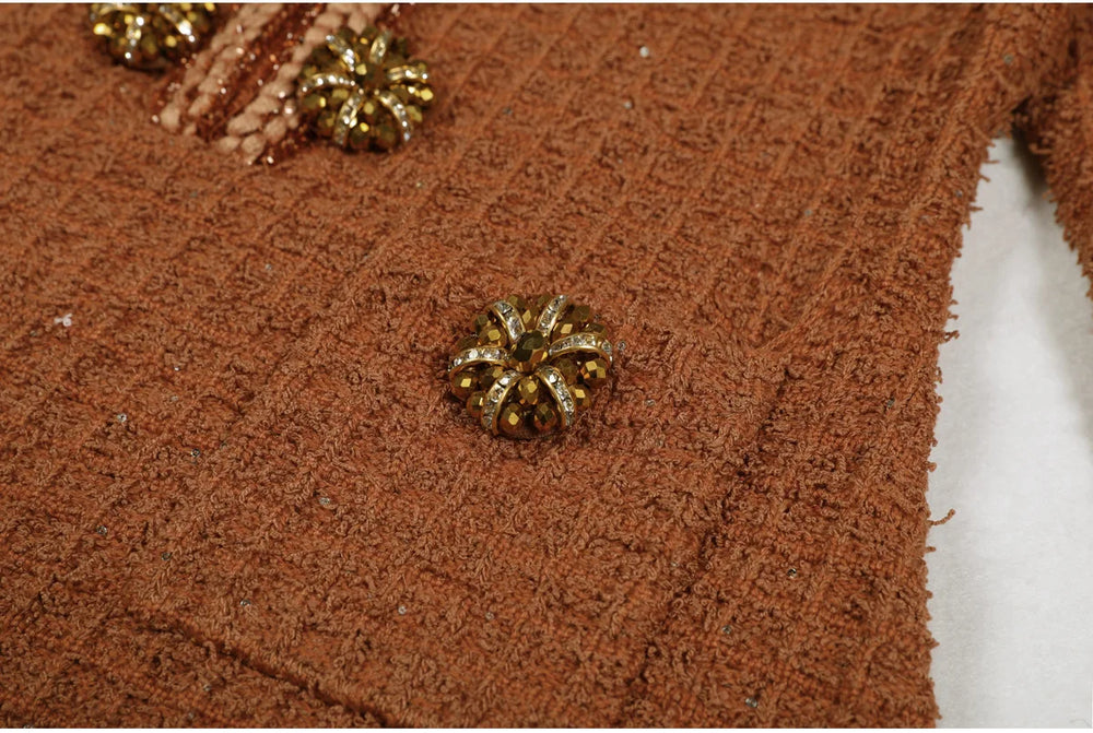 Close-up of a brown textured fabric with decorative gold buttons.