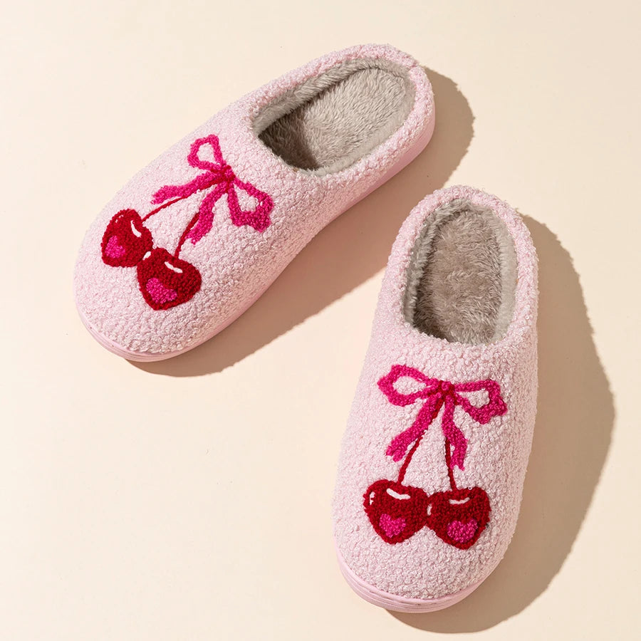 Top view of pink plush slippers with cherry bow embroidery