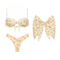 Underwire bikini top and bikini bottoms with cherry print and lace trim, alongside a large bow detail cover-up.