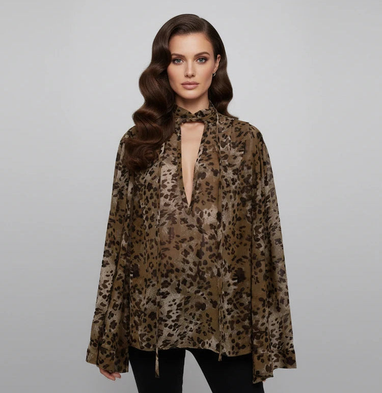 Woman wearing a leopard print blouse against a gray background