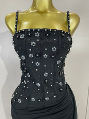 Side profile of a black embellished bodycon dress on a mannequin
