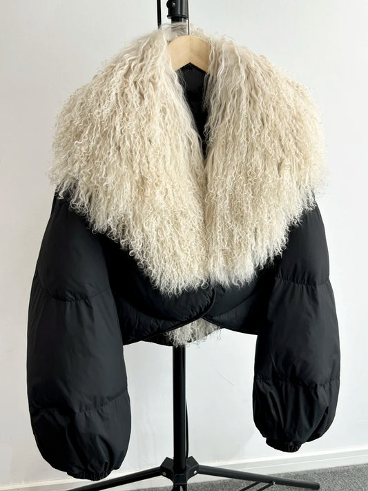 Black cropped puffer jacket with a large curly textured fur collar and full sleeves.
