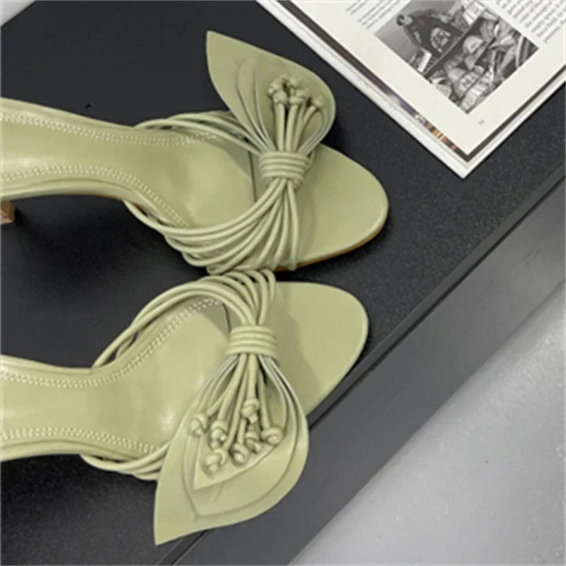 Pair of light green heeled slides on a black surface