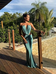 Teal halter neck draped maxi dress with gold chain detail on a wooden deck