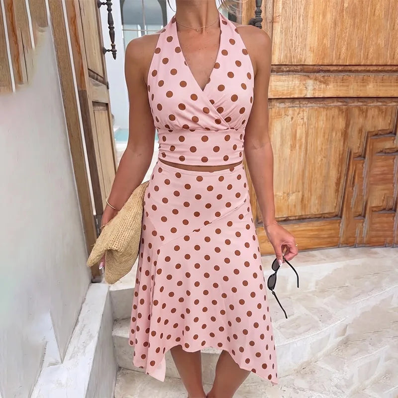 Close-up of pink polka dot halter crop top and asymmetric midi skirt.