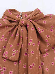 Brown fabric with pink floral pattern and a knot on a white background
