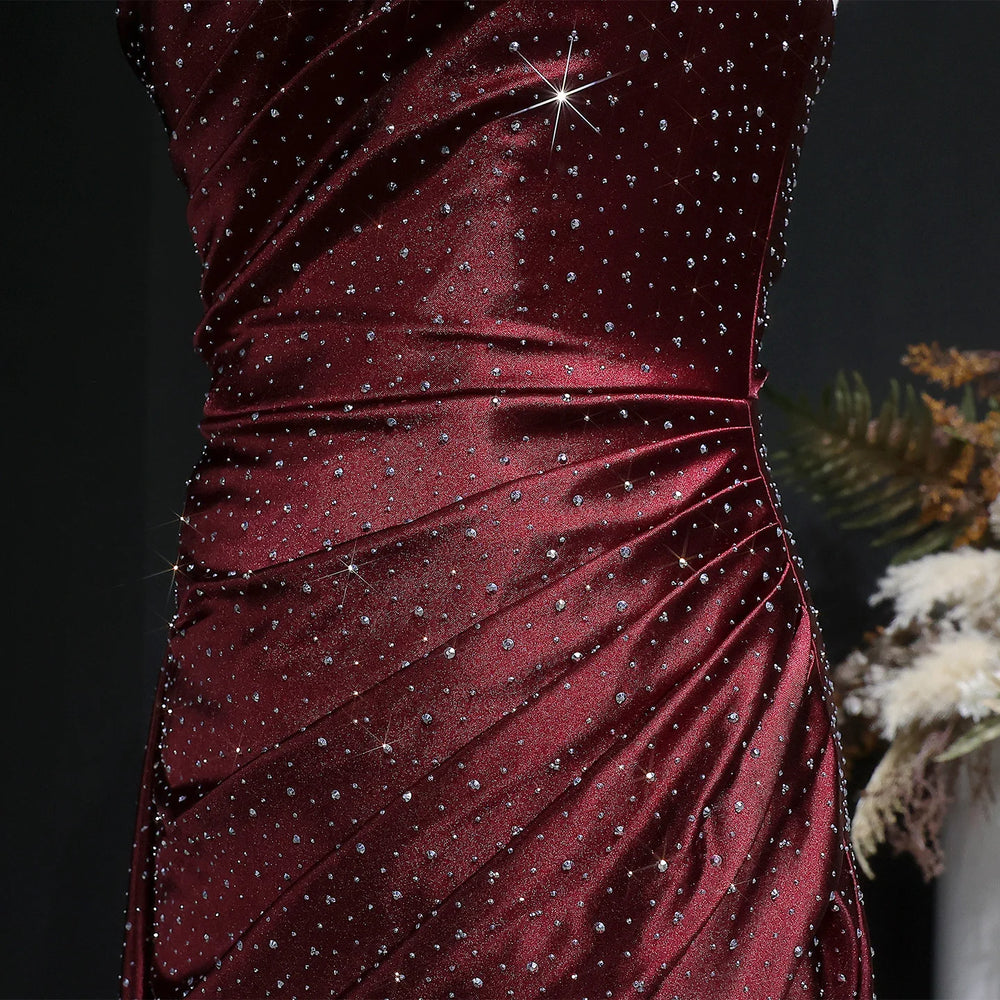 Close-up of a burgundy dress with sparkling embellishments on a dark background