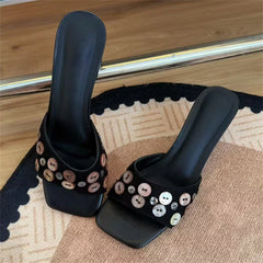 Pair of black square toe mules with shell button accents