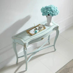 Light blue console table with decorative items on a white floor