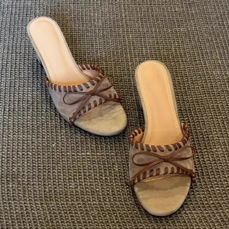 Khaki open toe square heel mules with stitched trim and bow detail, top down view