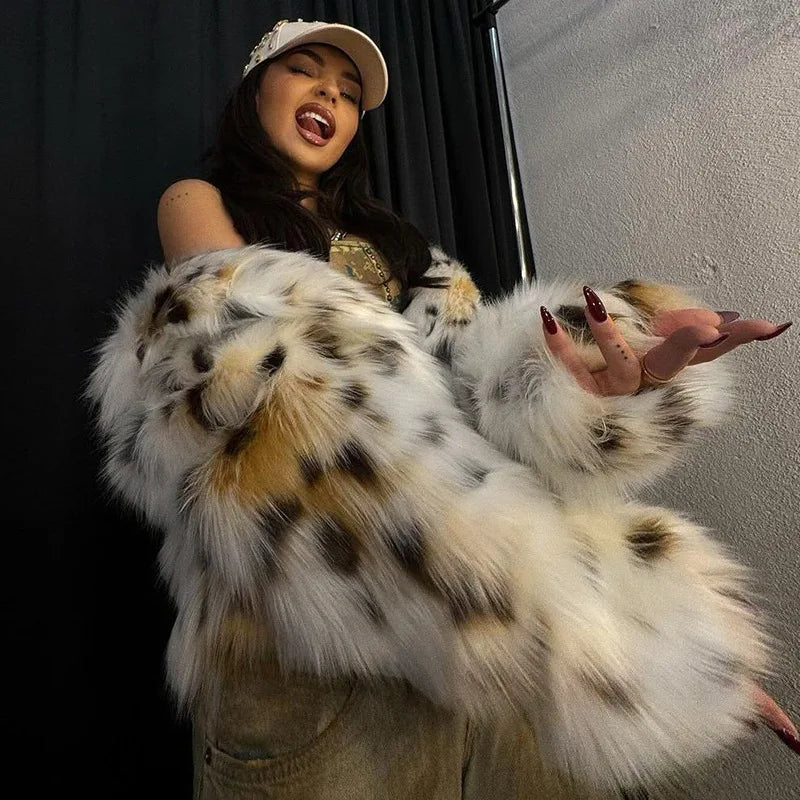 Person wearing a fluffy white and brown coat with a black background