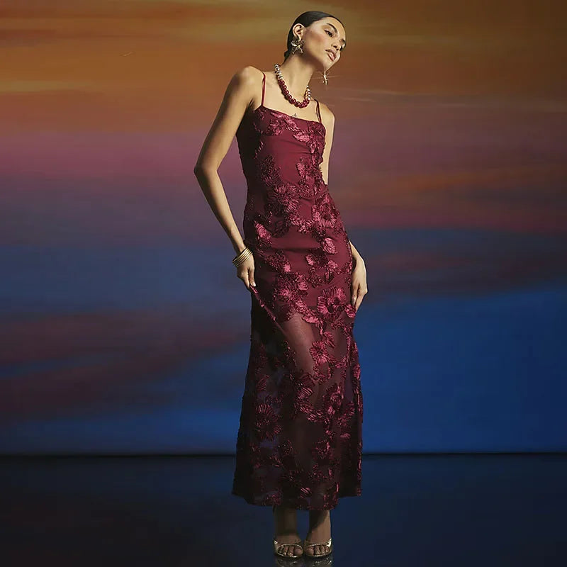 Woman in a burgundy evening gown against a colorful gradient background