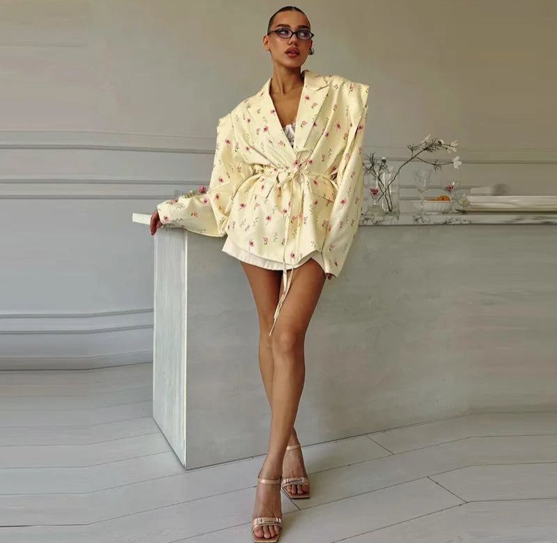 Woman in a light-colored outfit standing in a minimalistic room.