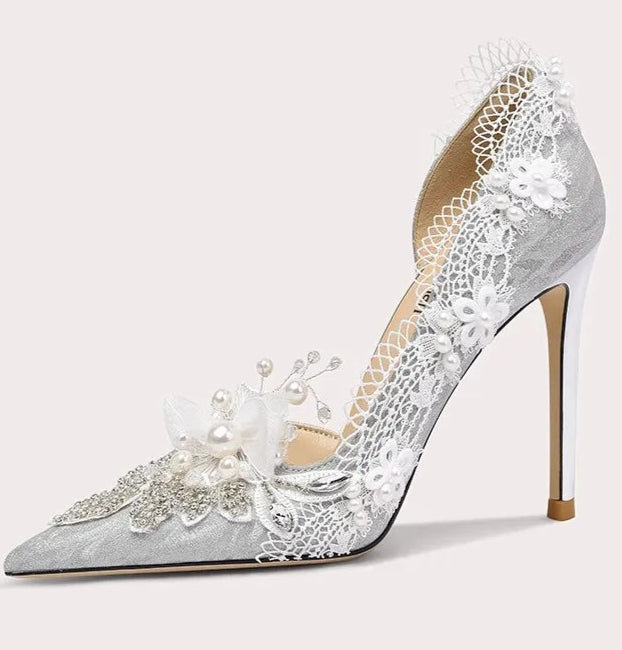 High-heeled shoe with lace and pearl details on a white background