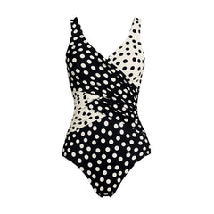 Polka dot one-piece swimwear with asymmetrical wrap detail.