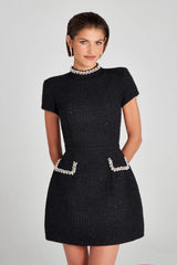 Black dress with decorative elements on a plain background