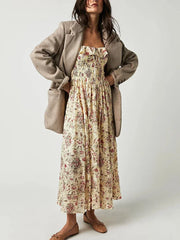 Woman wearing a floral dress and beige coat on a white background