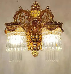 Decorative gold wall sconce with crystal accents on a plain background