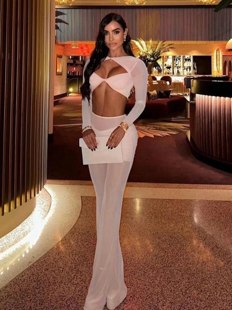 Woman in a white outfit posing in an elegant indoor setting