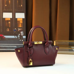 Structured leather top-handle bag with gold hardware and chain strap, side view