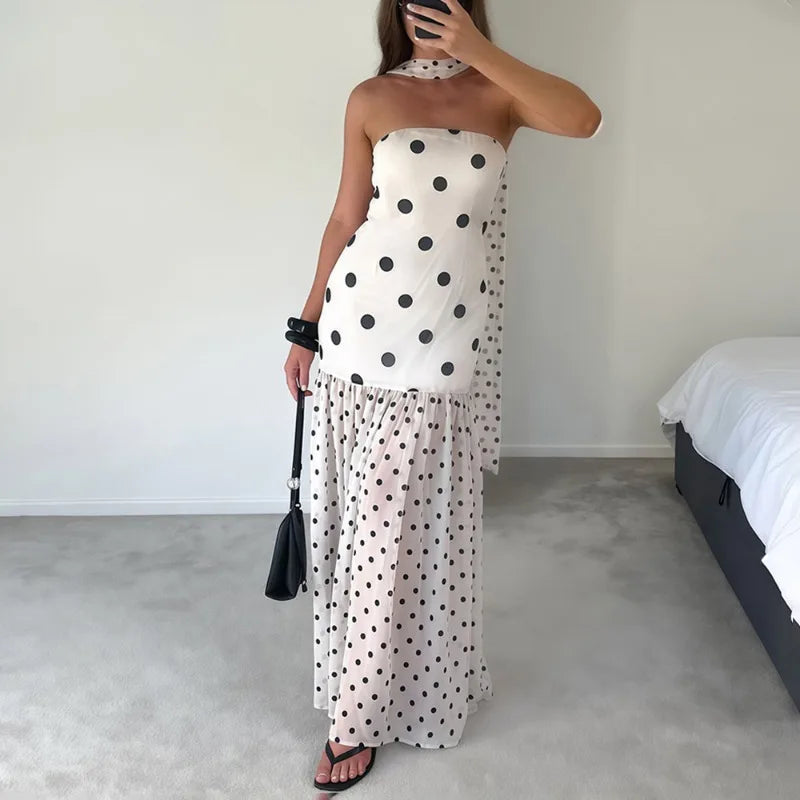 Model wearing a white polka dot maxi dress with scarf