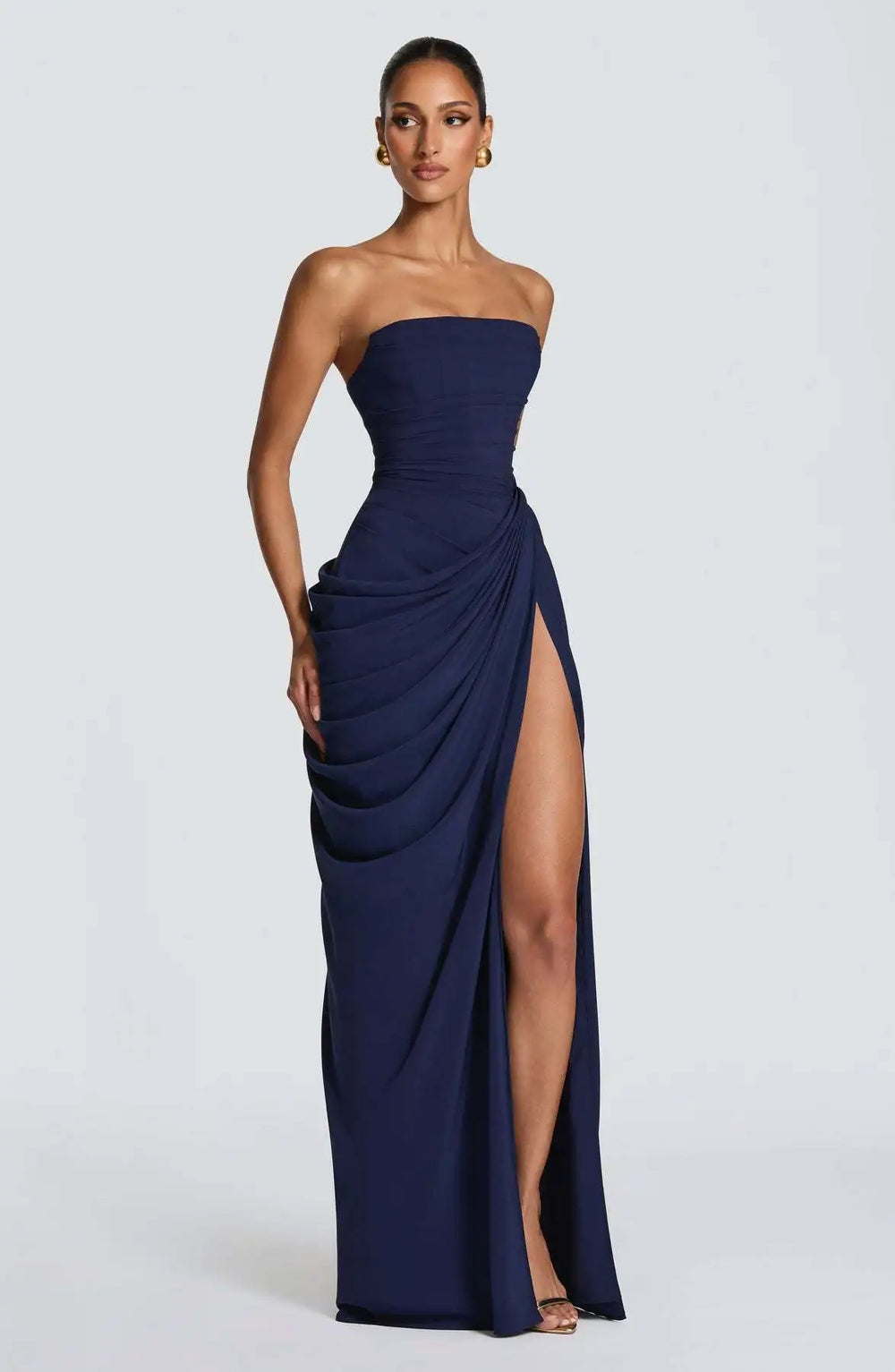 Navy strapless gown with a high slit on a white background