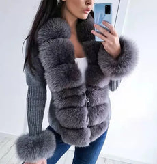 Person wearing a gray fur coat taking a mirror selfie.