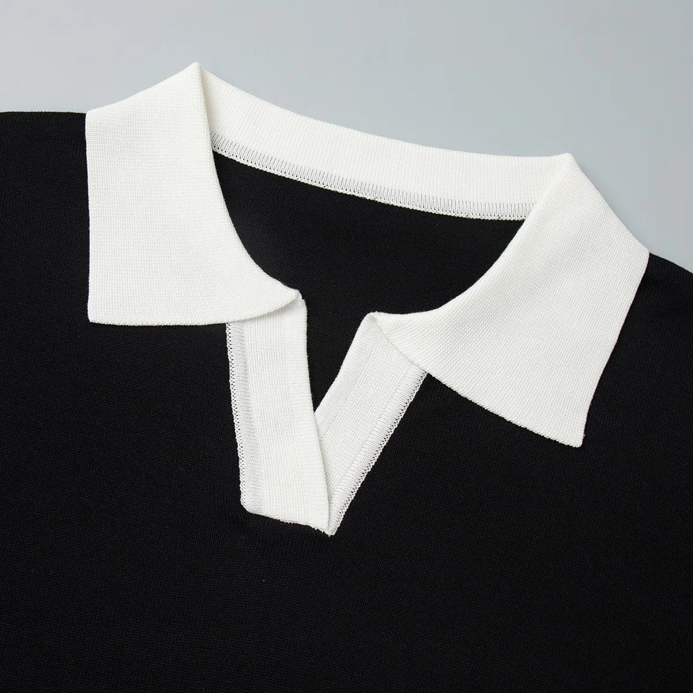 Black sweater with a white collar on a gray background