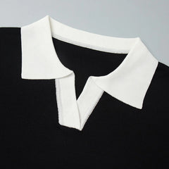 Black sweater with a white collar on a gray background