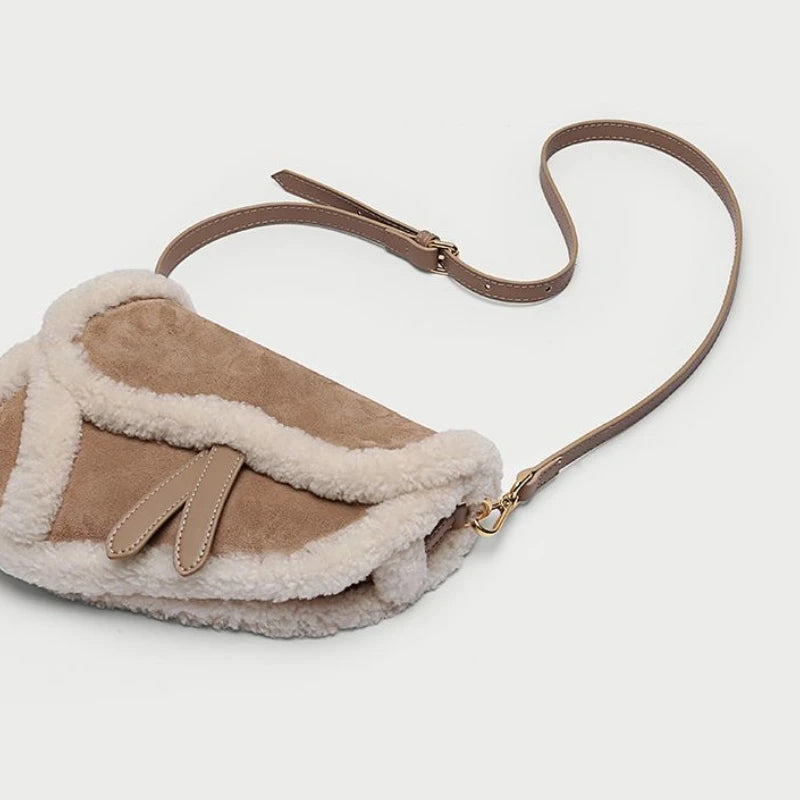Shearling trim saddle bag angled view with strap
