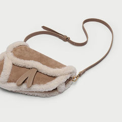 Shearling trim saddle bag angled view with strap