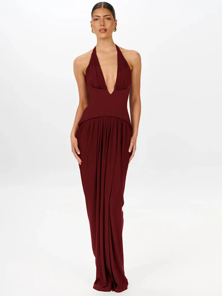 Woman wearing a burgundy halter neck gown on a white background