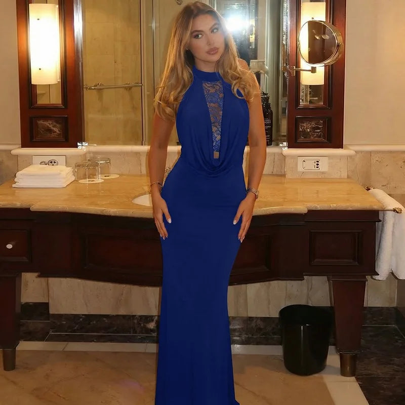 Woman in a blue dress standing in a bathroom.