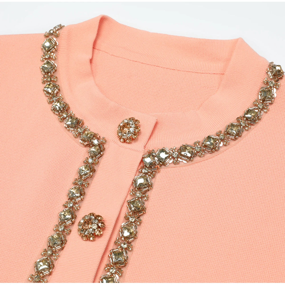 Close-up of pink knit top embellished neckline and buttons